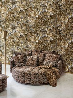 a leopard print couch and ottoman in front of a wall