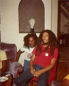 two young men sitting next to each other in a living room