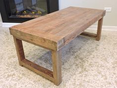 a wooden table sitting in front of a fire place