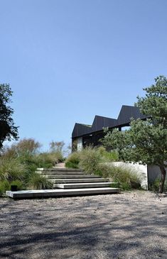 an outdoor staircase leading up to a house with trees and grass on the ground below