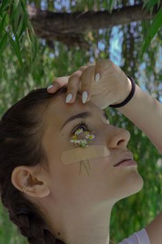 a woman with her eye patch taped to her forehead and looking up at the sky