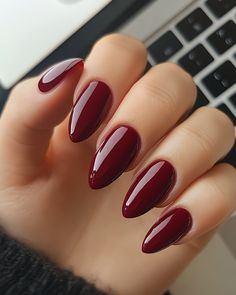 Elegant, glossy, deep red almond-shaped nails perfect for adding a rich and luxurious vibe to your style. The sleek finish gives a sophisticated cherry cola hue that shines with a high-gloss finish. Perfect for fall and winter looks, this design complements bold and classic outfits. Regular Almond Nails, Almond Nails Cherry Red, Cherry Cola Nails Designs, Cherry Cola Red Nails, Deep Red Nails Almond, Almond Nails Dark Red, Cherry Red Nails Almond, Dark Red Oval Nails