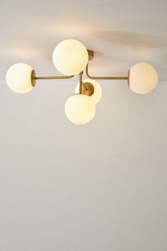 three lights are hanging from the ceiling in a room with white walls and flooring