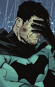 a man dressed as batman in the rain with his hands on his face and eyes closed