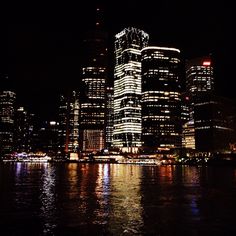 the city is lit up at night and it looks like they are floating in the water