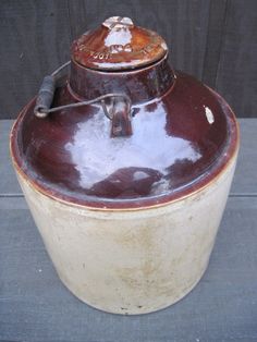 an old brown and white pot sitting on top of a table