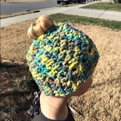 a young child wearing a multicolored knitted beanie hat on top of his head