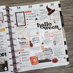 an open planner book with halloween stickers and writing on the pages, sitting on a wooden table