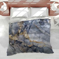 a bed covered in a blue and gold marble comforter