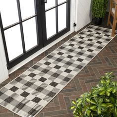 a black and white checkered rug sitting on top of a floor next to a door