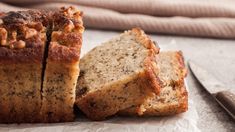 two pieces of bread sitting on top of a piece of paper next to a knife