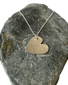 A  handmade sterling silver hammered finish heart necklace features a heart-shaped pendant that measures 30mm in size. The heart pendant is crafted from sterling silver and has a hammered finish, which adds texture and shine to the piece. The pendant is suspended from a delicate sterling silver chain that is available in two lengths: 40cm or 45cm. The chain is also made from high-quality sterling silver and has a sleek and smooth finish that complements the hammered texture of the pendant. The n Hammered Sterling Silver Necklaces For Anniversary, Sterling Silver Hammered Necklaces For Anniversary, Sterling Silver Hammered Necklace For Anniversary, Anniversary Sterling Silver Hammered Necklace, Heart-shaped Hammered Sterling Silver Jewelry, Sterling Silver Hand Stamped Heart Necklace, Sterling Silver Hand Stamped Heart Pendant Necklace, Hammered Silver Heart Jewelry, Silver Hand Stamped Heart Necklace For Anniversary