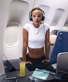 a woman wearing headphones sitting in front of a laptop computer on top of a desk