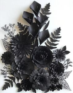 black paper flowers and leaves on a white background