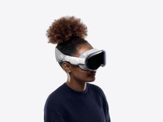 a woman wearing a virtual reality headset and looking into the distance with an afro wig on her head