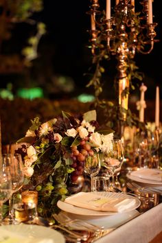 the table is set with wine glasses, plates and silverware for an elegant dinner