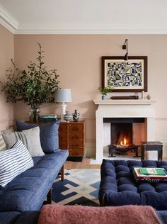 a living room filled with furniture and a fire place under a painting on the wall