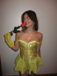 a woman wearing a yellow corset and holding a red rose in her hand