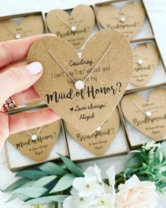 a person holding a heart shaped necklace in front of a box with other hearts on it