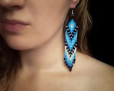 a close up of a person wearing some kind of blue beaded earring on their neck