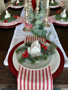 the table is set for christmas with red and white plates