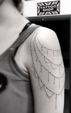 black and white photo of a woman's arm with a feather tattoo on it