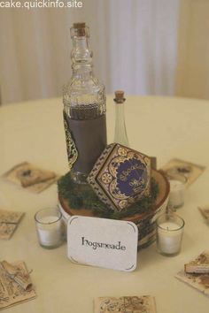 a table topped with a bottle of liquid and candles