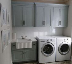 a washer and dryer in a small room next to a window with pictures on the wall