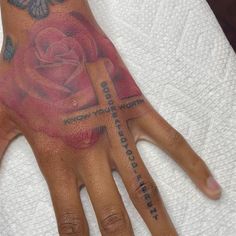 a person's hand with tattoos on it and a rose tattooed on the palm