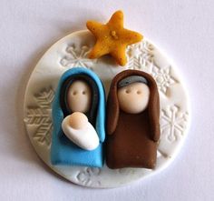 two small figurines sitting on top of a white plate next to a star