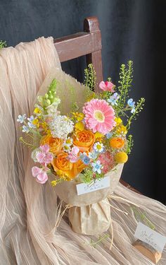 a bouquet of flowers sitting on top of a wooden chair