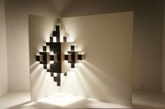 the light shines on an art piece in a room with white walls and flooring