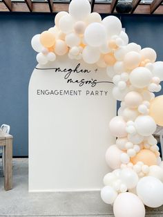 an arch made out of balloons with the words engagement party written on it