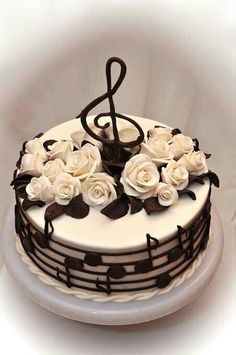 a cake decorated with music notes and white roses