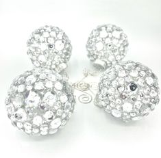 three silver balls with white and clear crystals