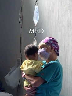 a woman holding a baby in her arms with the words med on it's side