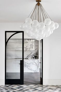 a chandelier hanging from the ceiling in a room with marble floors and walls