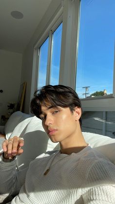 a young man sitting on top of a white couch