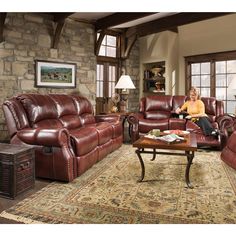 a woman sitting in a living room next to two couches and a coffee table