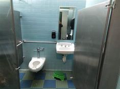 a public bathroom with blue and green tiles