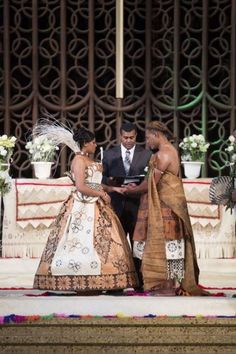 two women and a man are dressed up in traditional african wedding attire, standing at the alter