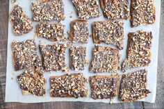 several pieces of chocolate and nuts on a piece of parchment paper