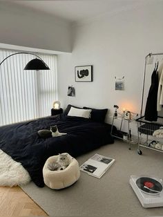 a bedroom with a bed, record player and other items on the floor in front of it