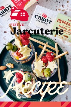 three small cups filled with fruit on top of a green plate next to crackers