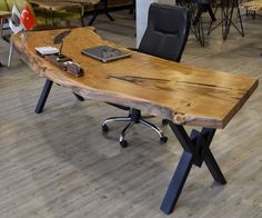 a wooden table sitting on top of a hard wood floor next to black leather chairs