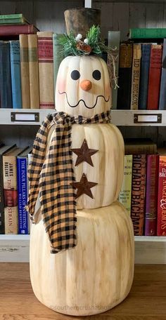 a wooden snowman sitting on top of a book shelf