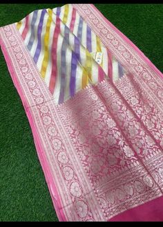 a pink and yellow sari laying on top of green grass