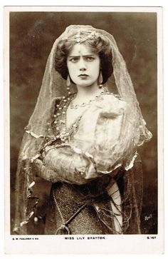 an old black and white photo of a woman wearing a veil