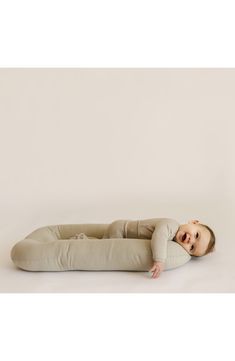 a baby is laying on the floor with his head resting on an inflatable pillow