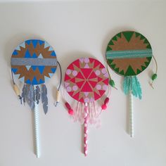 three decorative paper lollipops with tassels on them